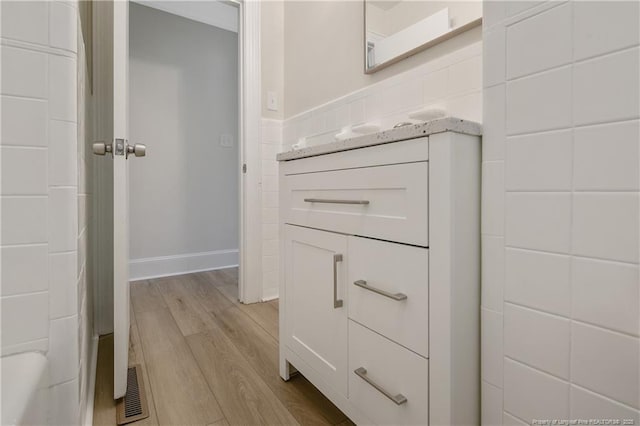 bathroom featuring visible vents, wood finished floors, and vanity