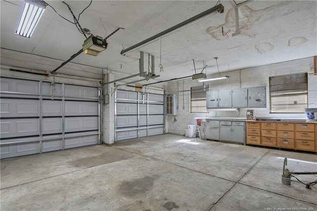 garage with concrete block wall and a garage door opener