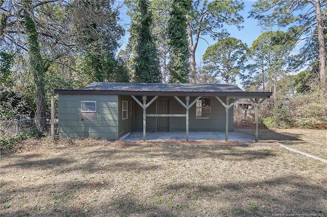 view of outdoor structure with a carport and fence