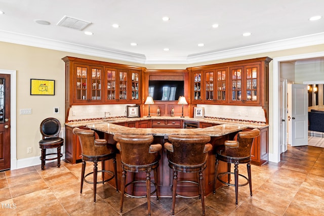 bar featuring indoor wet bar, visible vents, ornamental molding, and tasteful backsplash