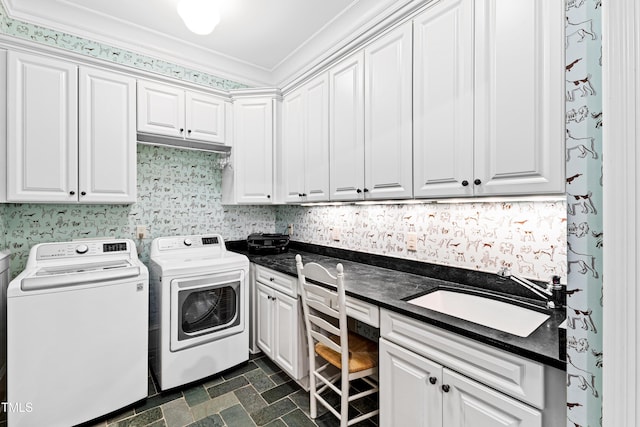 laundry room with crown molding, washing machine and clothes dryer, cabinet space, a sink, and wallpapered walls