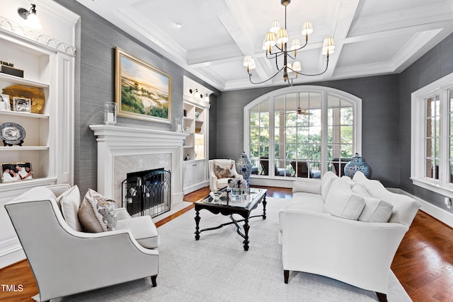 living room featuring built in shelves, beamed ceiling, wood finished floors, and a high end fireplace