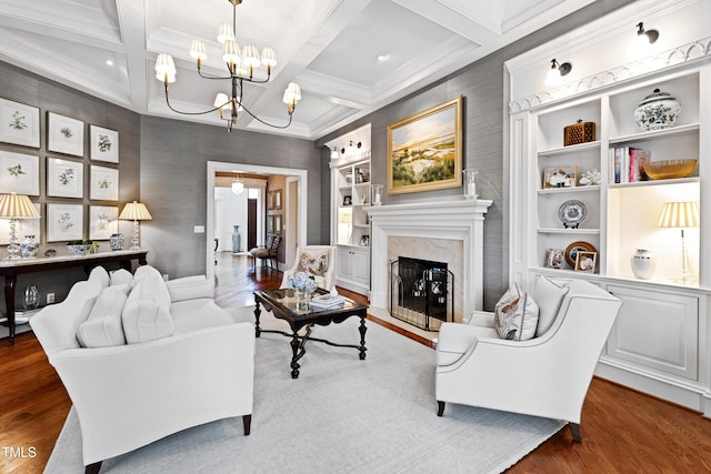 living room with beam ceiling, a fireplace, a chandelier, and wood finished floors