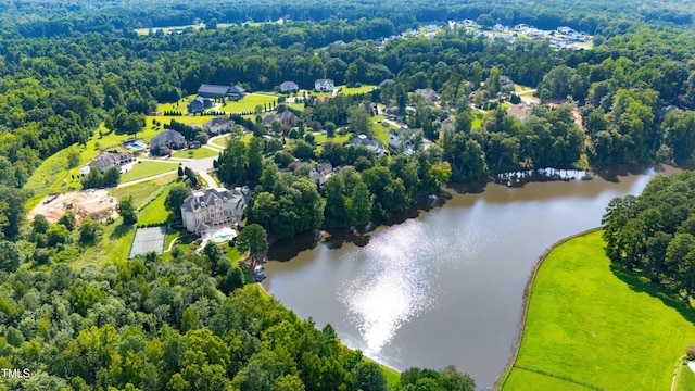 drone / aerial view with a water view and a forest view