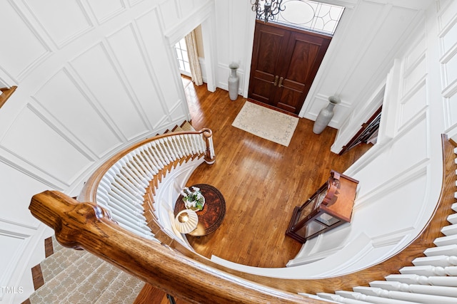 entryway with stairway, wood finished floors, and a decorative wall