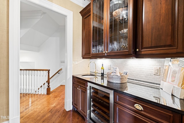 bar with decorative backsplash, wine cooler, dark wood-type flooring, wet bar, and a sink