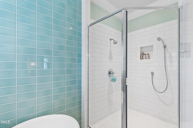 full bath featuring a shower stall, a freestanding bath, and crown molding