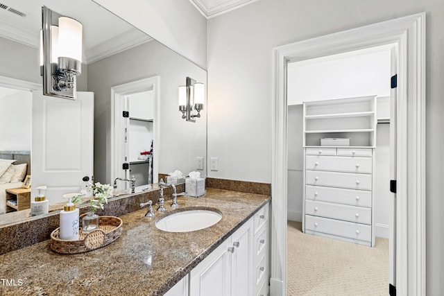 bathroom featuring ornamental molding, visible vents, a spacious closet, and vanity