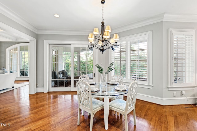 dining area featuring crown molding, baseboards, and wood finished floors