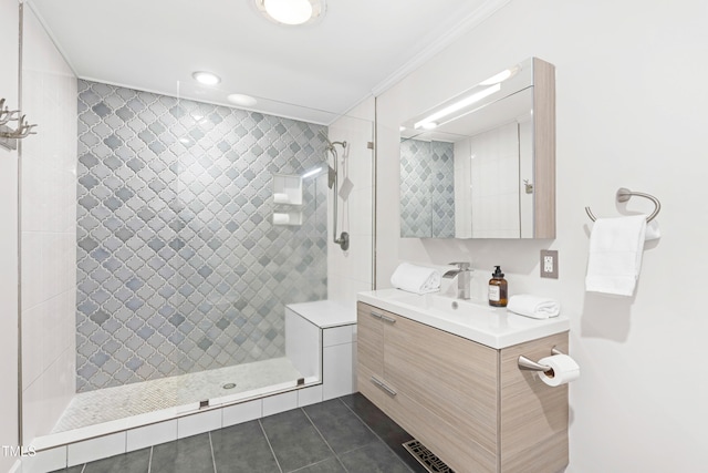 bathroom with crown molding, visible vents, vanity, tile patterned flooring, and tiled shower