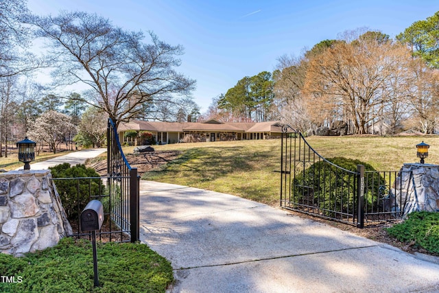 exterior space with a front lawn, fence, and a gate