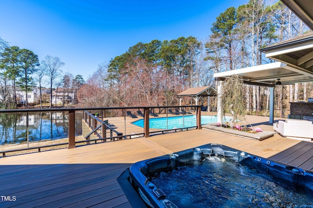 exterior space with a gazebo, a ceiling fan, a fenced in pool, and hot tub deck surround