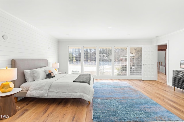 bedroom with crown molding and wood finished floors