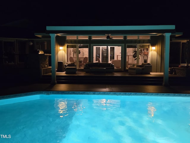 pool at night with an outdoor pool and outdoor lounge area