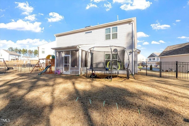 back of house with a trampoline, a sunroom, a playground, and fence