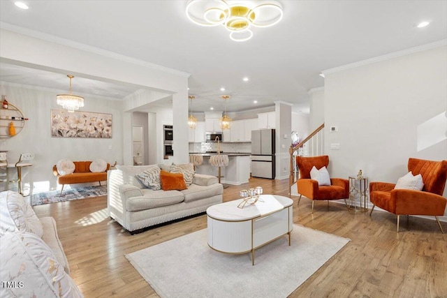 living area with a chandelier, ornamental molding, light wood finished floors, and stairs