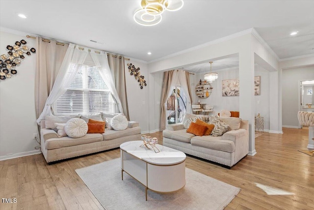 living area with visible vents, baseboards, an inviting chandelier, crown molding, and light wood-style floors