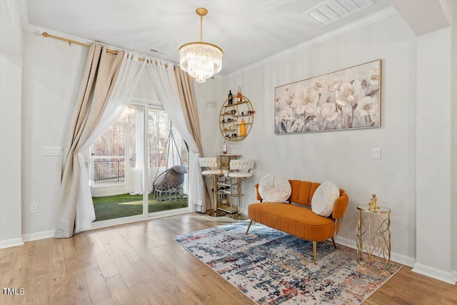 living area with ornamental molding, wood finished floors, and baseboards