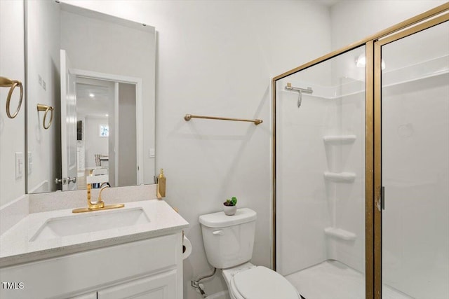 bathroom with a shower stall, toilet, and vanity