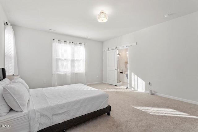 carpeted bedroom with a barn door and baseboards