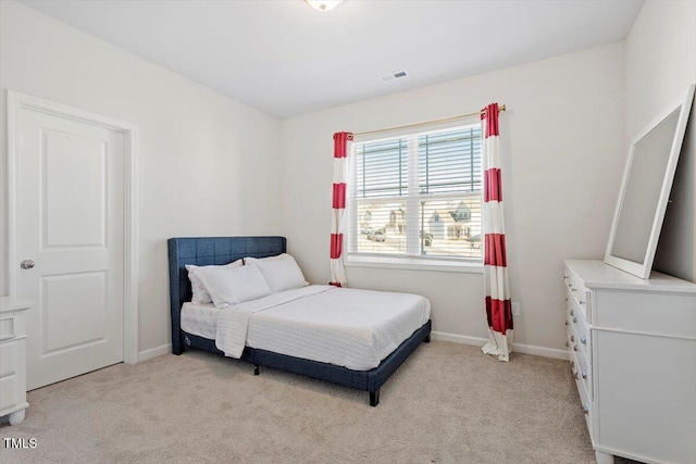 bedroom with baseboards, visible vents, and light colored carpet