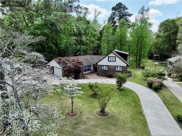 1855 Riverside Blvd, Lumberton, NC 28358 - english style home with a chimney, a garage, a front lawn, and brick siding