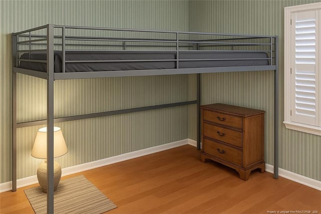 1855 Riverside Blvd, Lumberton, NC 28358 - unfurnished bedroom with wood finished floors, baseboards, and wallpapered walls