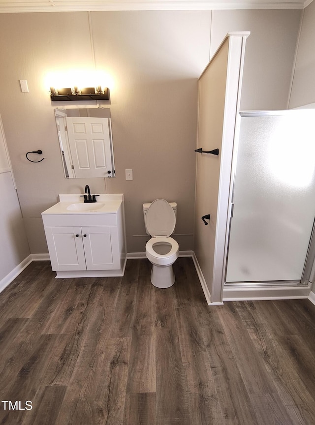 full bathroom with toilet, a stall shower, vanity, wood finished floors, and baseboards