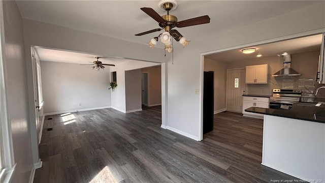 1809 Wayne Ln, Fayetteville, NC 28304 - kitchen with white cabinetry, wall chimney range hood, dark wood-style floors, dark countertops, and stainless steel range with electric stovetop