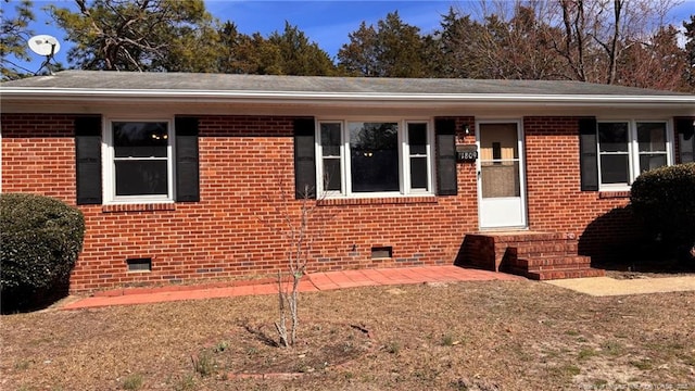 view of front of home featuring crawl space and brick siding