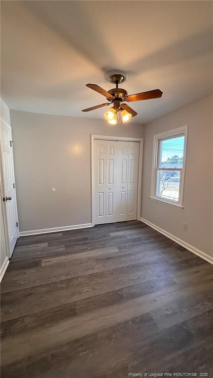 1809 Wayne Ln, Fayetteville, NC 28304 - unfurnished bedroom with dark wood-style floors, a closet, baseboards, and a ceiling fan