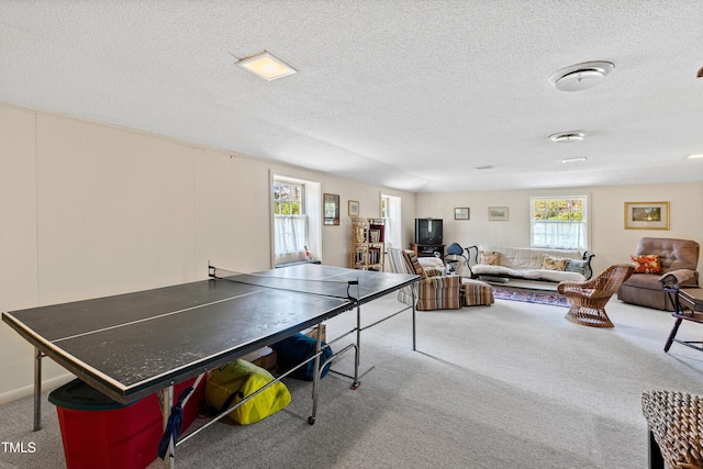 game room with a textured ceiling and carpet floors