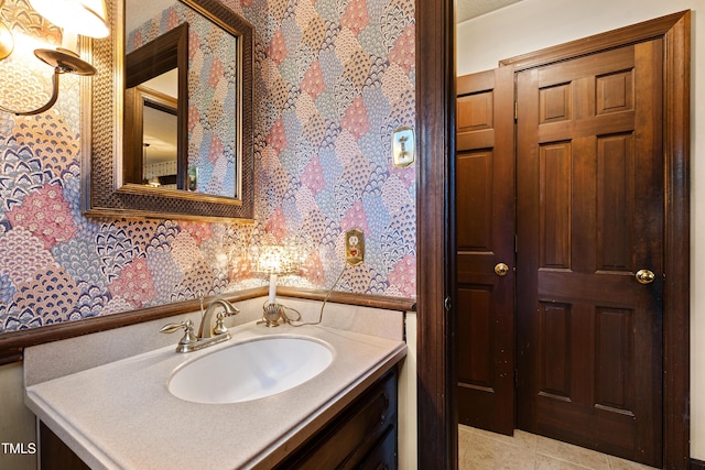 bathroom with tile patterned floors, vanity, and wallpapered walls