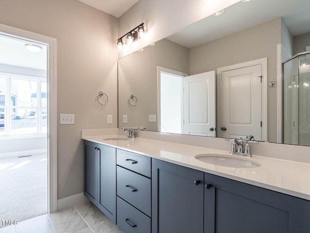 full bathroom featuring a stall shower, marble finish floor, a sink, and double vanity