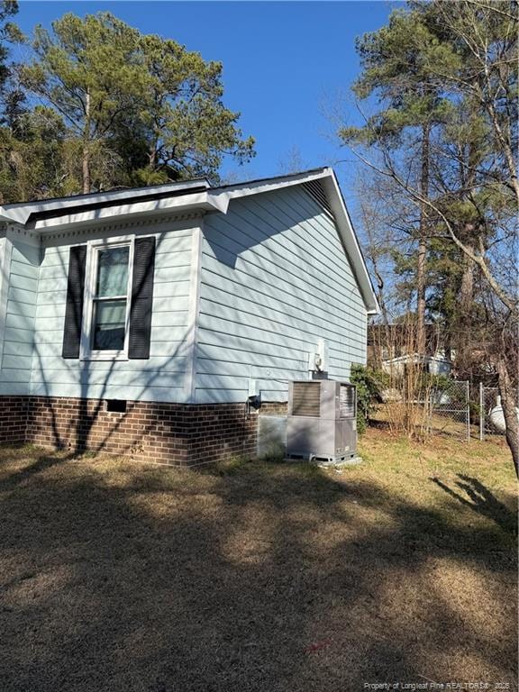 view of home's exterior with crawl space, central AC, and a lawn