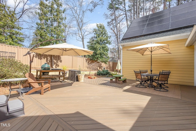 deck with a fenced backyard and outdoor dining area