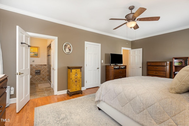 bedroom with ceiling fan, baseboards, light wood finished floors, ensuite bath, and crown molding