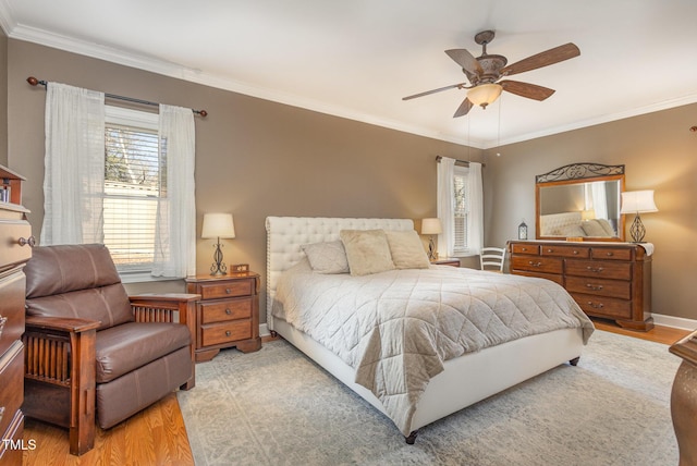 bedroom with ceiling fan, ornamental molding, wood finished floors, and baseboards