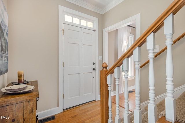 entryway featuring baseboards, visible vents, stairway, crown molding, and light wood-type flooring