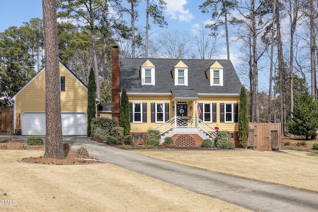 cape cod home with a garage, roof with shingles, a chimney, and fence