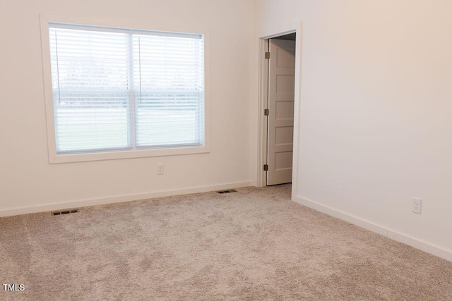 carpeted empty room with visible vents and baseboards