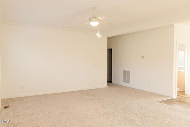 spare room featuring baseboards, visible vents, ornamental molding, and light colored carpet