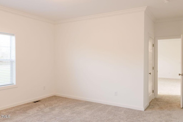 spare room featuring ornamental molding, light colored carpet, visible vents, and baseboards