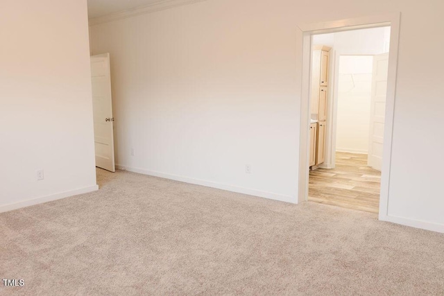 unfurnished room with light carpet, baseboards, and ornamental molding