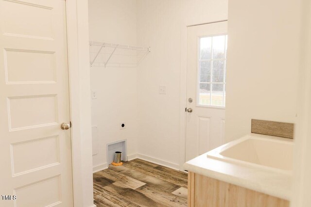 laundry area featuring laundry area, baseboards, electric dryer hookup, and wood finished floors