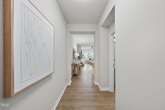 hallway featuring baseboards and wood finished floors