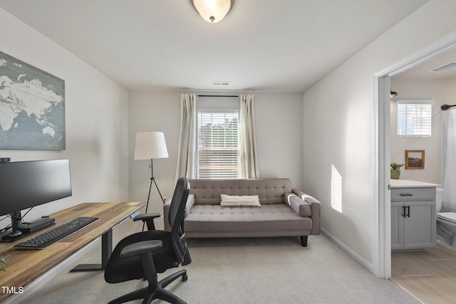 office space with light carpet, plenty of natural light, and visible vents