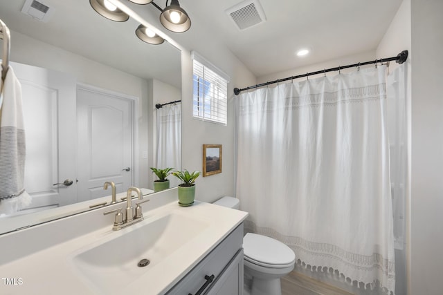 bathroom with toilet, vanity, visible vents, and a shower with curtain