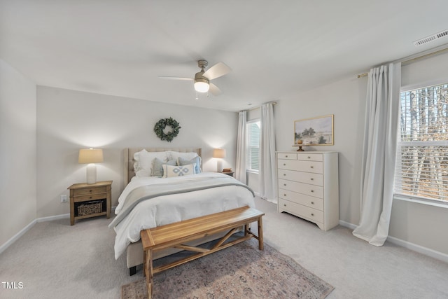 bedroom featuring a ceiling fan, visible vents, light carpet, and baseboards