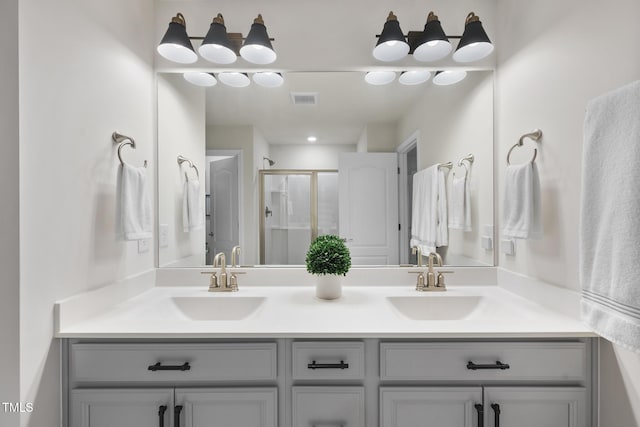 full bathroom with a stall shower, visible vents, a sink, and double vanity